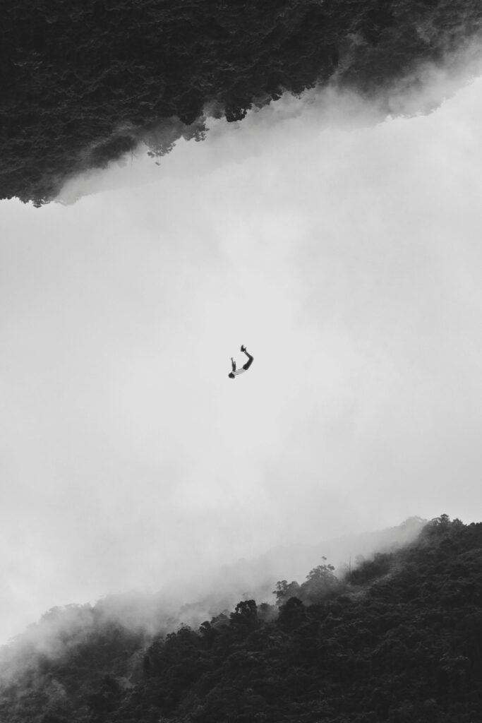 pexels-photo-1793525-1793525 Silhouetted person mid-air against a fog and forest backdrop in Shiding District, Taiwan.